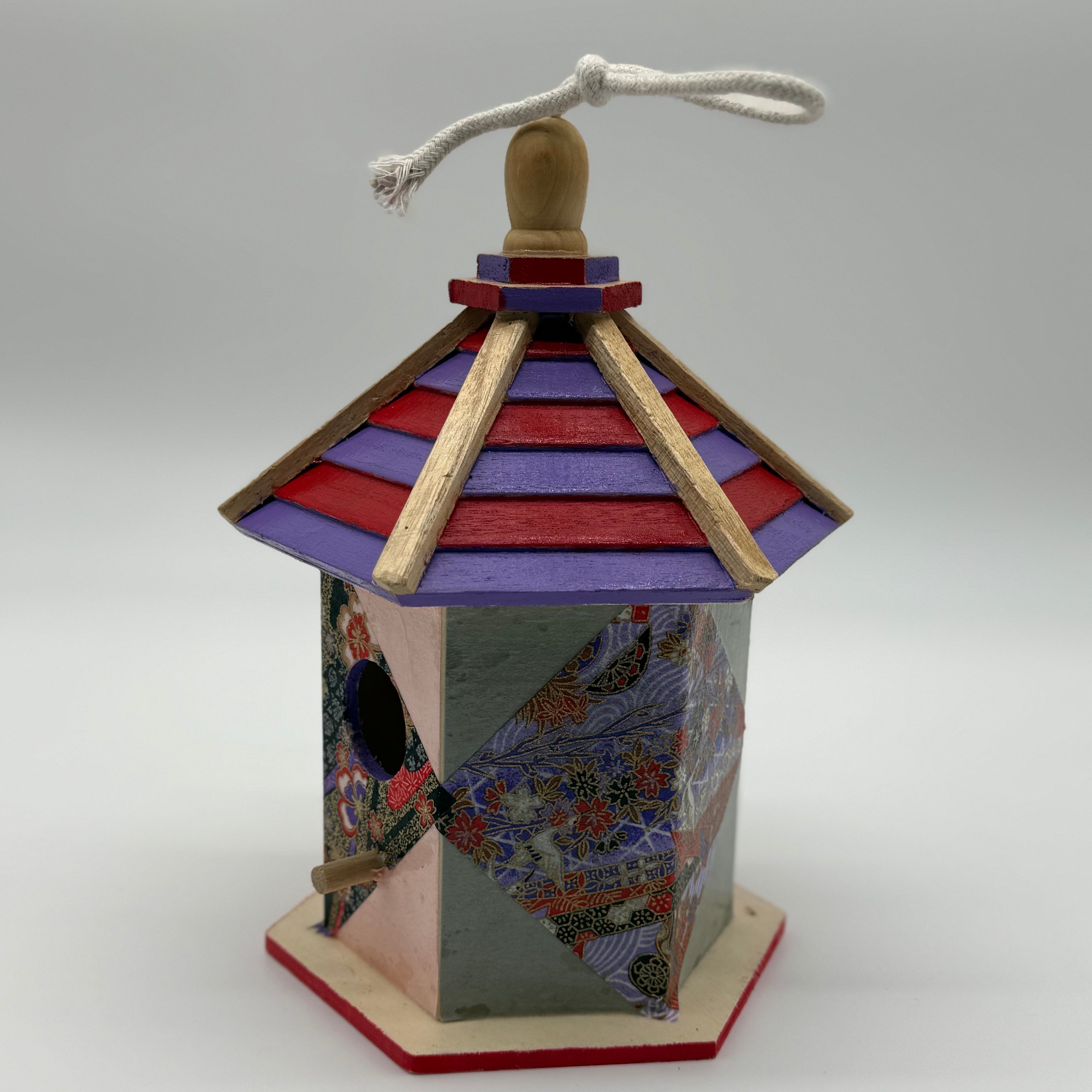 Decorative birdhouse with colorful design on a white background